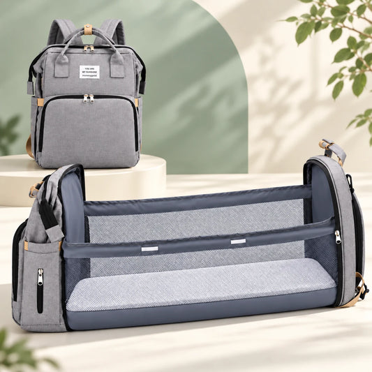 The same gray diaper backpack shown closed and opened into a fold-out changing space with mesh sides and a flat pad. Two configurations of one product.