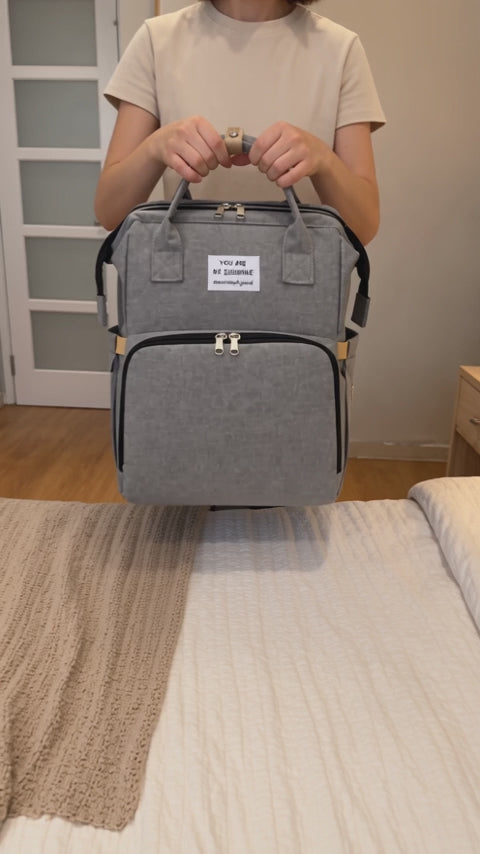 Load video: The gray diaper backpack unfolds into a changing space.